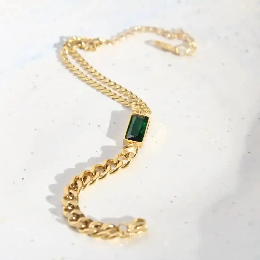 Gold chain bracelet with a green gemstone